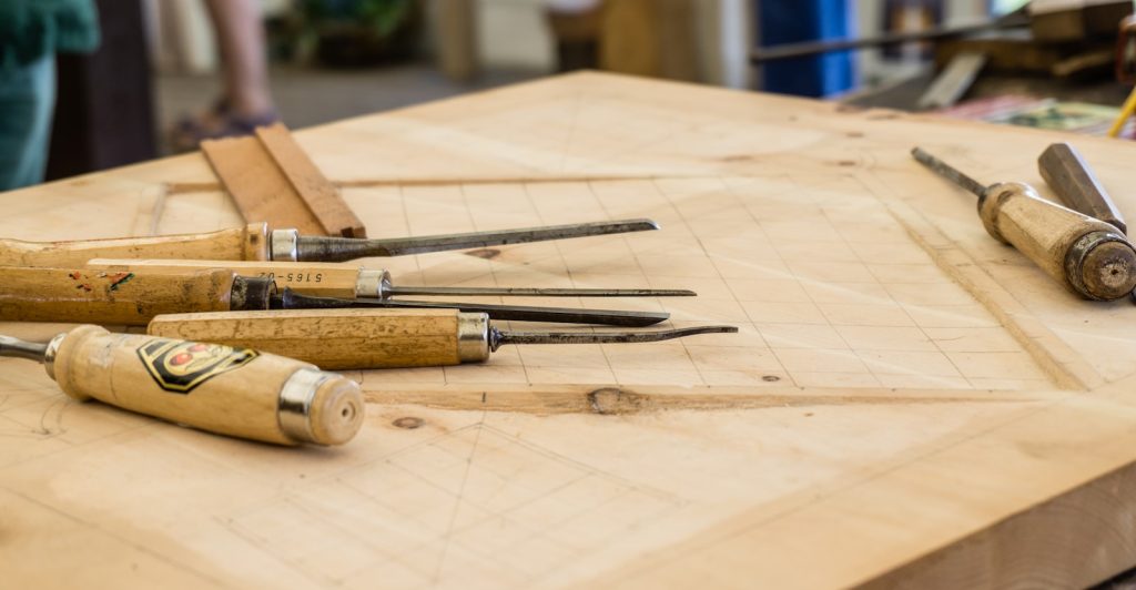 Assorted hand tools laid out on a workshop bench
