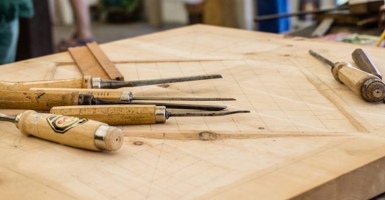 Assorted hand tools laid out on a workshop bench
