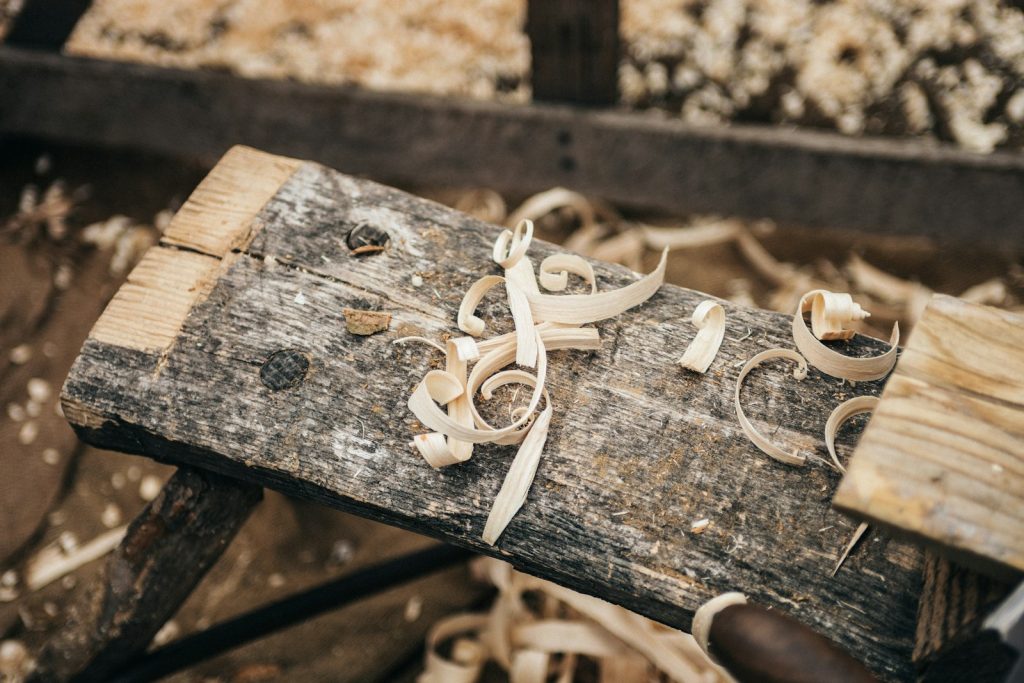 Fine sawdust and shavings scattered across a wooden plank