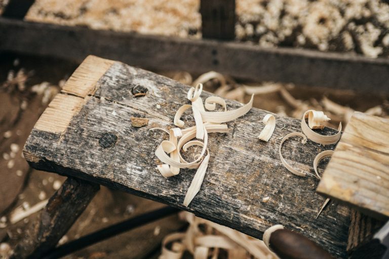 Fine sawdust and shavings scattered across a wooden plank